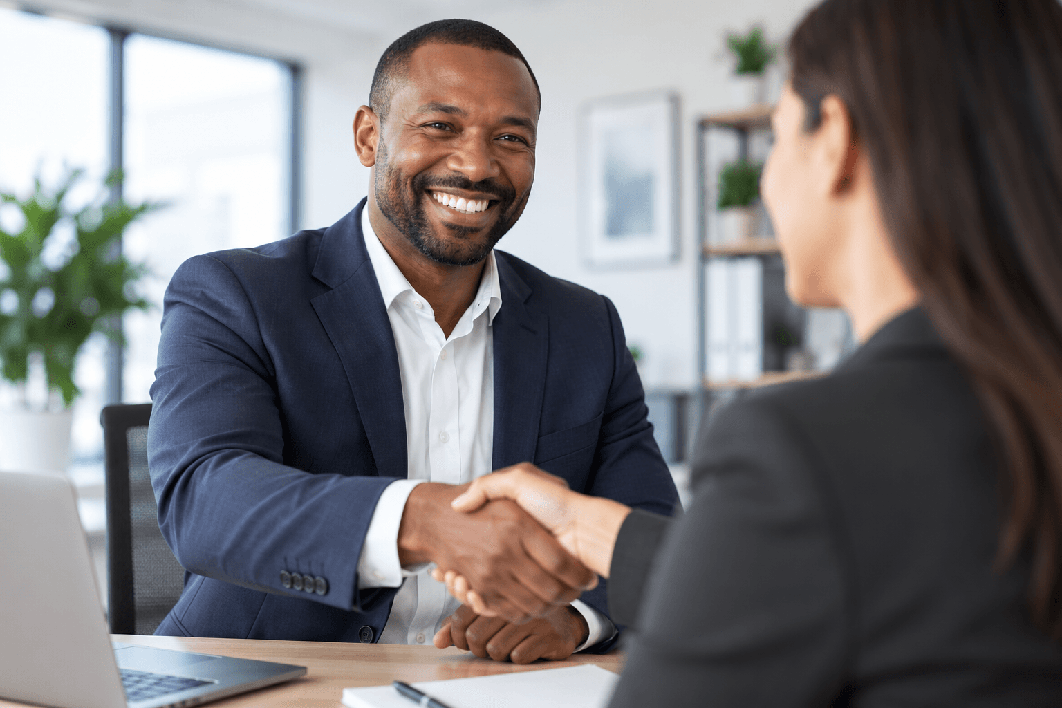 A hiring manager shaking hands with a candidate